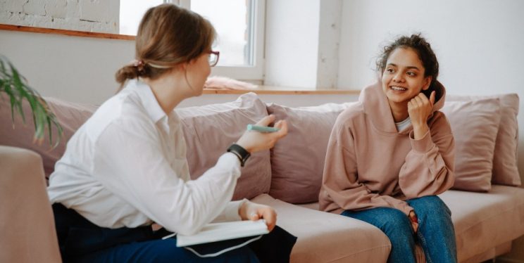 A young person looking relaxed talking to an adult