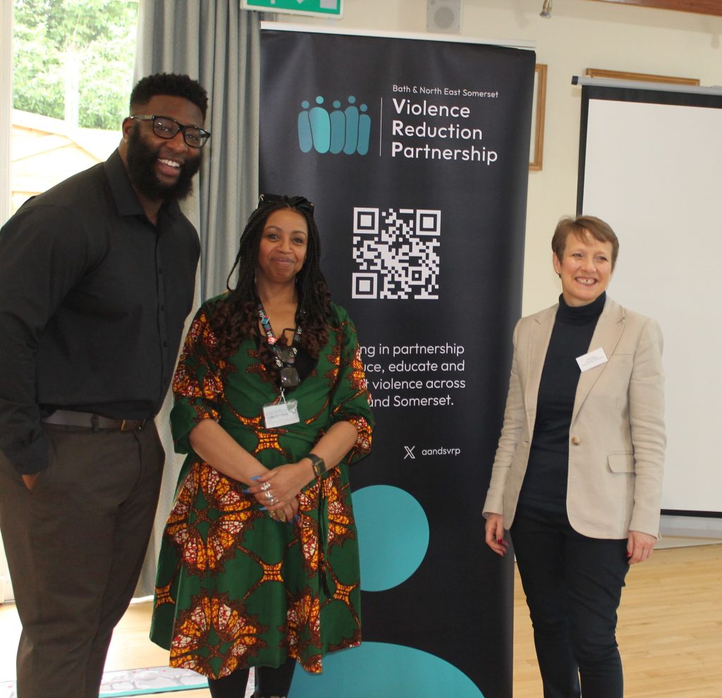 An image of Chief Executive of Solve Craig Pinkney, Sophia McKenzie BANES VRP and PCC Clare Moody stood in front of a banner for the Violence Reduction Partnership